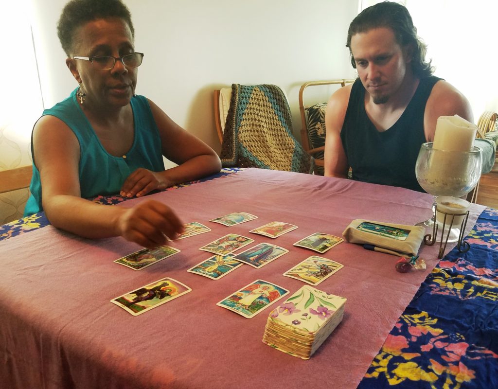 A woman giving a tarot card reading to a young man